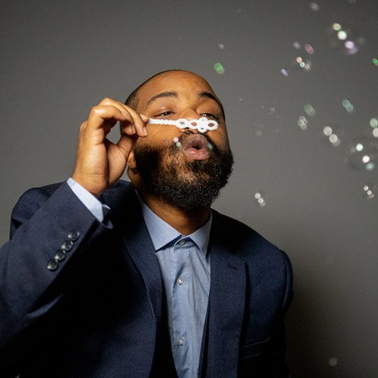 man in suit blowing bubbles