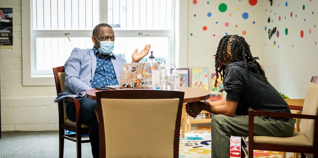 therapist sitting at a table with a patient talking