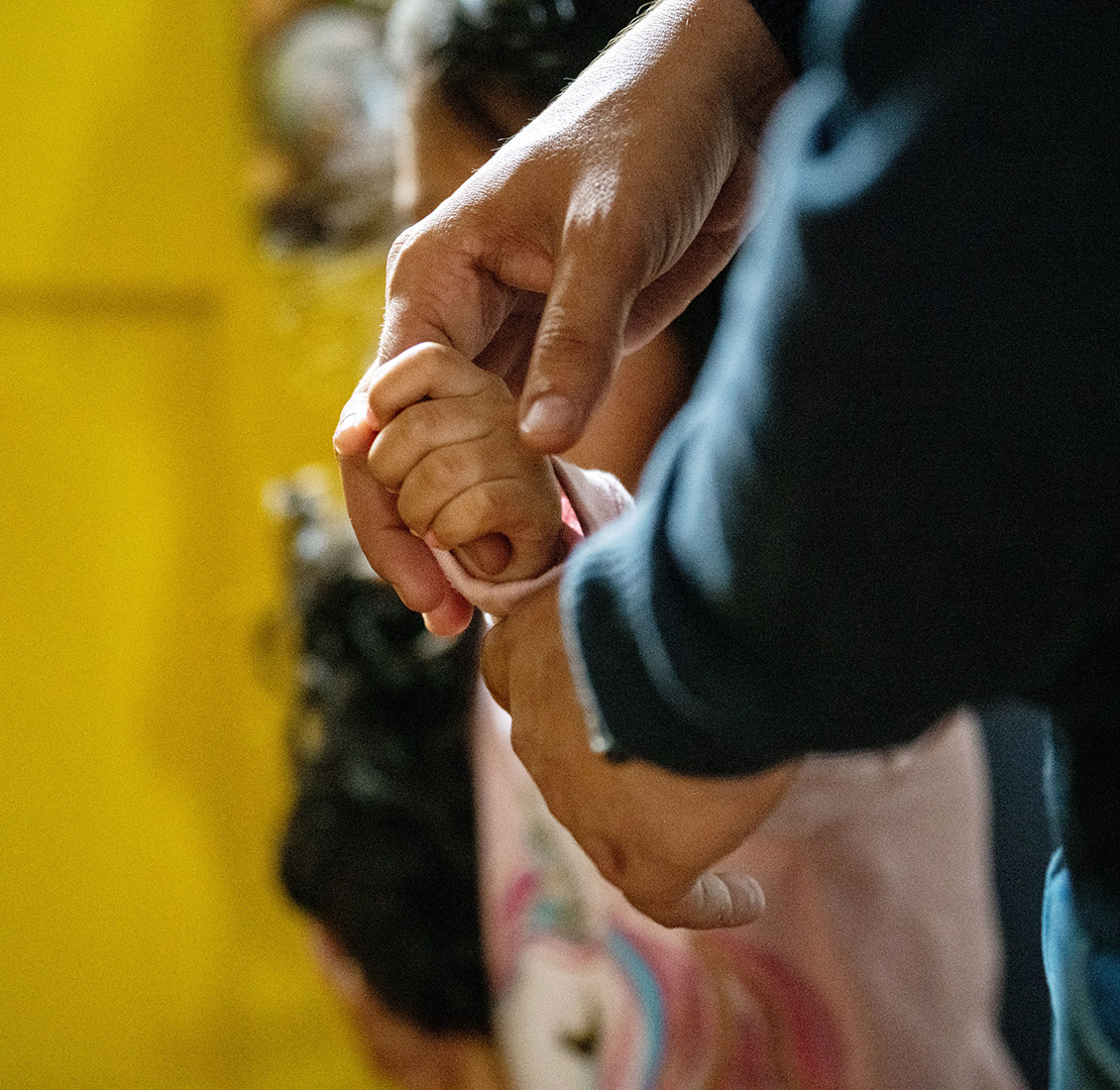 young child holding man's hand