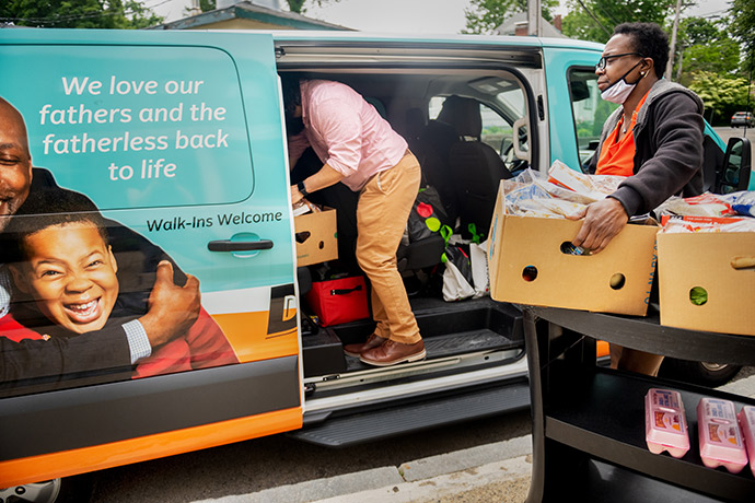 man and woman loading boxes of donated items into a van